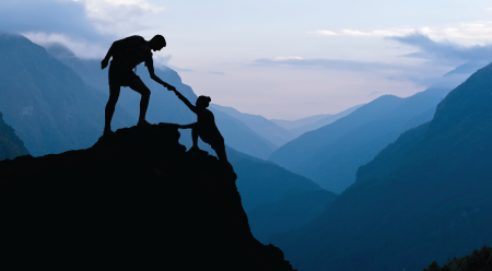 hiker helping a fellow hiker up