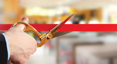 scissors cutting a red ribbon