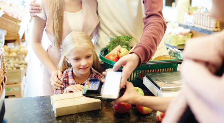 child looking at point of sale system processing a payment